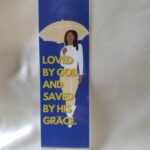 Love and Grace Laminated Bookmark blue background with a faceless figure holding an umbrella walking forward and a quote written in gold about love and grace by Beatrice Garrett.