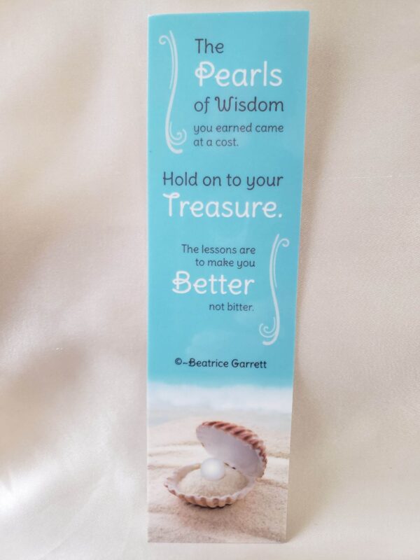 Wisdom Quote Laminated Bookmark calming ocean-blue background and white sand and pearl in an open seashell and on the left and right side decorative scroll in white with a quote about wisdom by Beatrice Garrett.